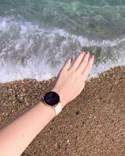ACTIVE 2 SMART WATCH on a hand near the ocean waves, showcasing a stylish design and a beach setting.