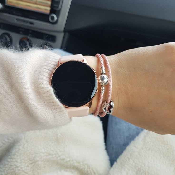 Person wearing ACTIVE 2 SMART WATCH with stylish bracelets, showcasing a modern look in a cozy setting.